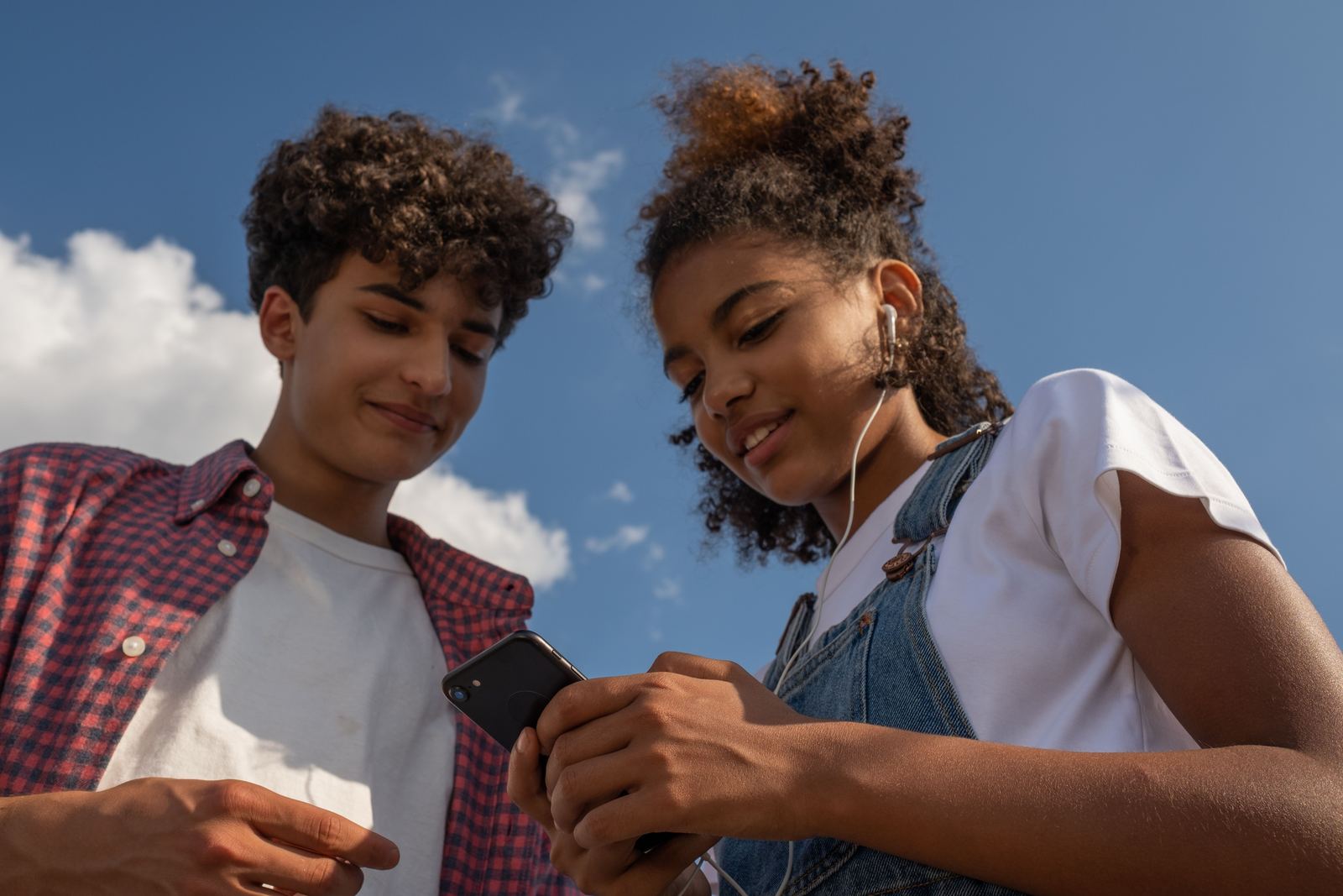 Adolescentes olhando para um celular em ambiente externo